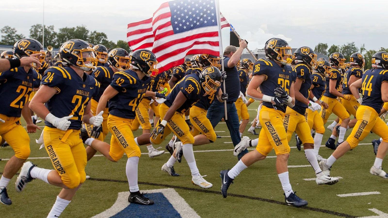 High school football team running onto the field